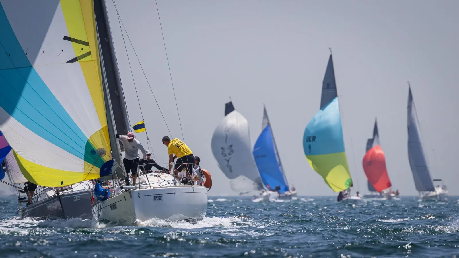 Keelboats under coloured spinnakers, a club photograph.