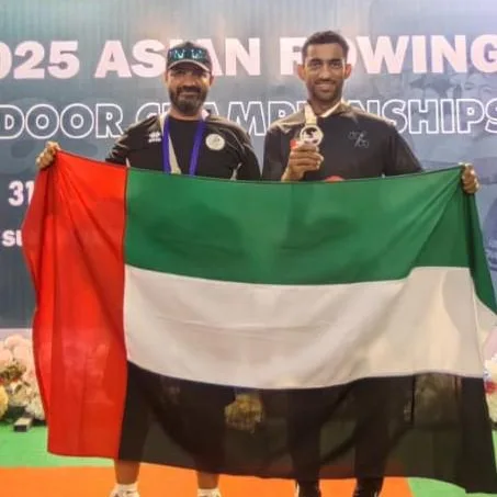 Two of the UAE team with the national flag at the 2025 Asian Rowing Indoor Championships
